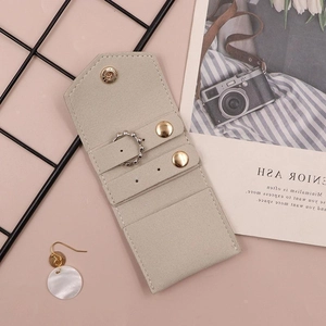 Travel jewelry pouch detail with golden snap button and ring holder storage section