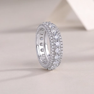 Macro shot of silver ring with three rows of moissanite stones and hollow side detail