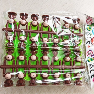Detail of brown plastic monkey figurines for balance tree educational game on wooden background
