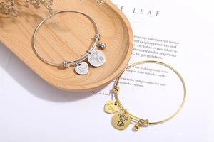 Detail of adjustable heart love charm bracelets in silver and gold stainless steel finish