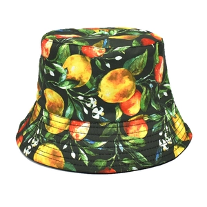 Detail of a black bucket hat with vibrant yellow lemon and green leaf prints on white background
