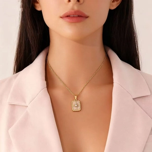 Golden necklace with heart and elephant pendant shown on model in professional lighting