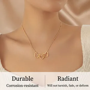 Close-up of gold-plated triple interlocking heart pendants on a sleek snake chain necklace