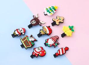Close-up of assorted Christmas hair clips featuring reindeer, Santa, and gingerbread motifs