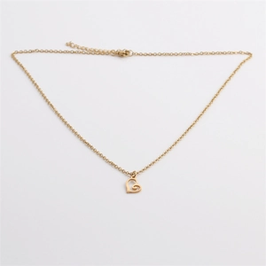 Macro detail of golden open-heart pendant on a sleek titanium steel chain necklace