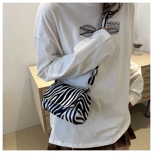 On-body shot of a mini zebra print crossbody bag showing size and casual styling