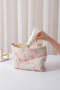 Close-up of a floral jacquard makeup bag with label showing storage of hand cream