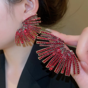 Detailed view of red rhinestone fan-shaped earrings with gold metal radiation design