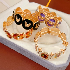 Detail of vintage gold bracelets with colorful enamel, butterfly relief and pearls