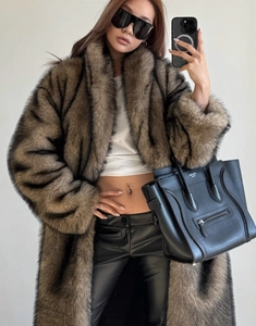 Detailed close-up of brown and black striped faux fox fur texture on a long winter coat