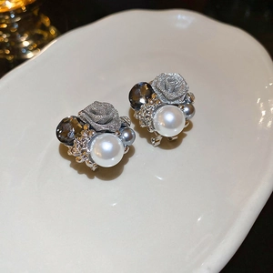 Gros plan de boucles d'oreilles rose vintage avec perles et cristal sur plateau céramique