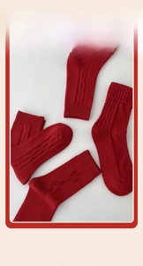 Detail of red crew socks with diamond knit patterns and thick ribbed cuffs for New Year