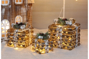 Close-up of lighted rattan Christmas gift boxes with pine cones and berries decoration
