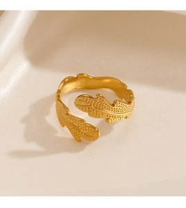 Detailed view of adjustable stainless steel leaf ring on a soft satin fabric background