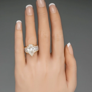 Close-up of gold ring featuring a pear-cut stone and micro-pave side diamonds