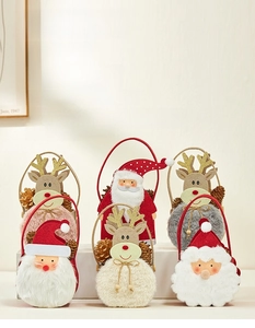 Detail of plush Christmas gift bags with Santa and reindeer designs and pinecone decor