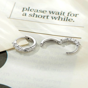 Silver huggie hoop earrings with marquise cubic zirconia stones and hinged clasp closure