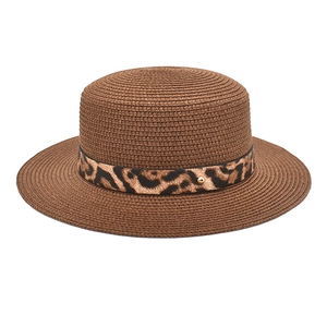 Dettaglio cappello di paglia marrone scuro con nastro leopardato e perla dorata