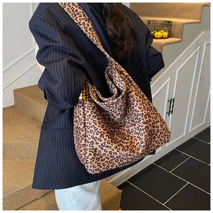 Detail of leopard print tote bag with distinctive wooden bead strap accents