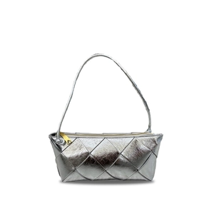Detailed macro view of silver metallic woven leather texture with a gold triangle zipper