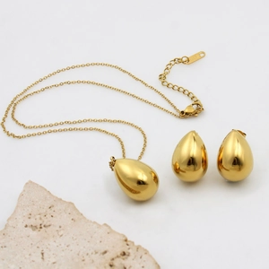 Minimalist gold teardrop necklace and earrings set with K18 engraving on white background