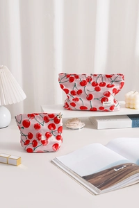Close-up of pink cherry print canvas makeup bags with flower zipper and brand label