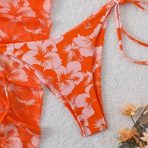 Detail of floral hibiscus print bikini with matching sheer orange mesh cover-up wrap