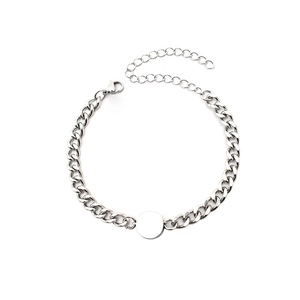 Detail view of silver Cuban link bracelet with a circular pendant and lobster clasp