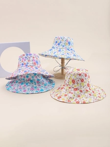 Detail view of four diverse floral patterns on wide-brim sun hats with fabric textures