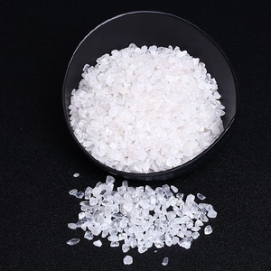 Macro view of irregular white translucent crystal stones in a matte black bowl for decor