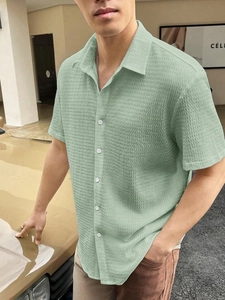 Close-up of sage green men's short sleeve shirt with unique seersucker wavy texture