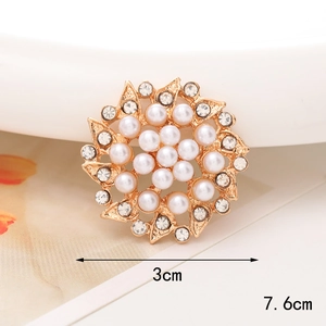 Detalle de broche de flor dorada de 3cm con perlas, pedrería y dimensiones claras