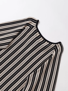 Détail du col en V et de la couture de l'épaule sur la robe en maille rayée noire