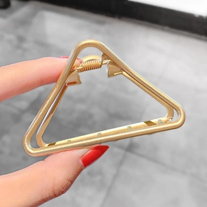 Detail of matte gold triangle hair claw clip made of alloy showing spring mechanism