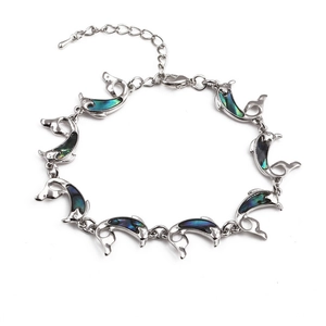 Detailed close-up of dolphin-shaped link bracelet with iridescent abalone shell inlays
