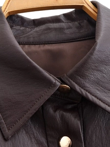 Close-up of deep brown faux leather coat featuring a lapel collar and gold metal buttons