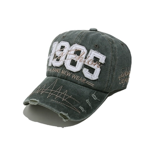 Close-up of distressed embroidery and 1985 patch on washed vintage baseball cap