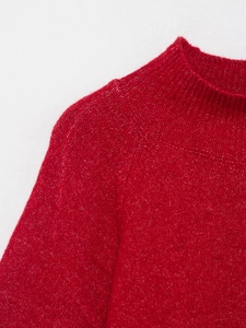 Close-up of red and white marled knit sweater showing ribbed turtleneck and plush texture