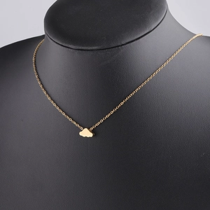 Detail of a minimalist gold cloud pendant necklace displayed on a black jewelry bust