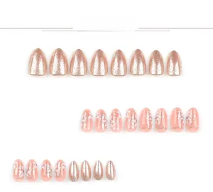 Detail view of almond press on nails featuring rose gold glitter and white floral art