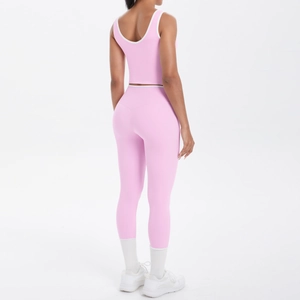 Detail view of the pink yoga set showing back cross design and contrast white piping