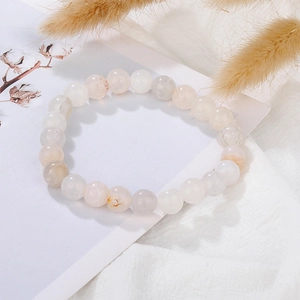 Close-up of natural lava stone bracelet with smooth white and pink marble crystal beads