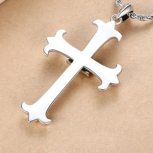 Polished silver Eye of Providence cross pendant with rope chain on a textured paper background