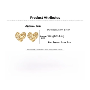 Detail view of heart-shaped gold alloy stud earrings with zircon and silver pins