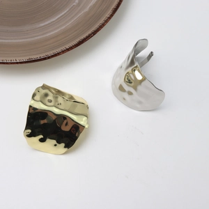 Close-up of gold and silver hammered metal hair clips with lava texture and open design
