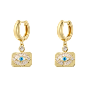 Detailed close-up of golden evil eye earrings with blue beads and cubic zirconia inlay