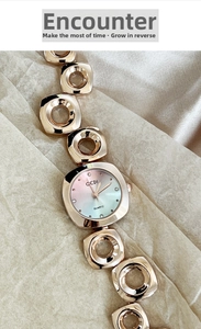 Detail of rose gold quartz watch with hollow geometric chain and gradient dial