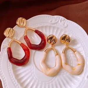 Vintage irregular wave drop earrings in amber red and cream white resin with gold finish
