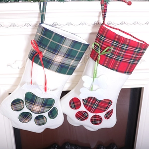 Pair of Christmas cat paw stockings in red and green plaid hanging on fireplace