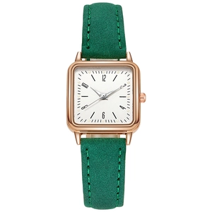 Detailed view of women's quartz watch with square rose gold case and green suede strap